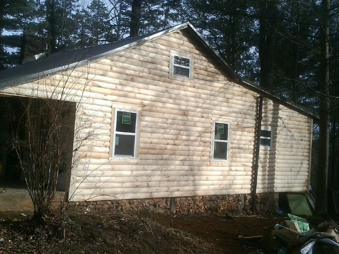 New log siding and dark metal roofing on a gable end in Mansfield