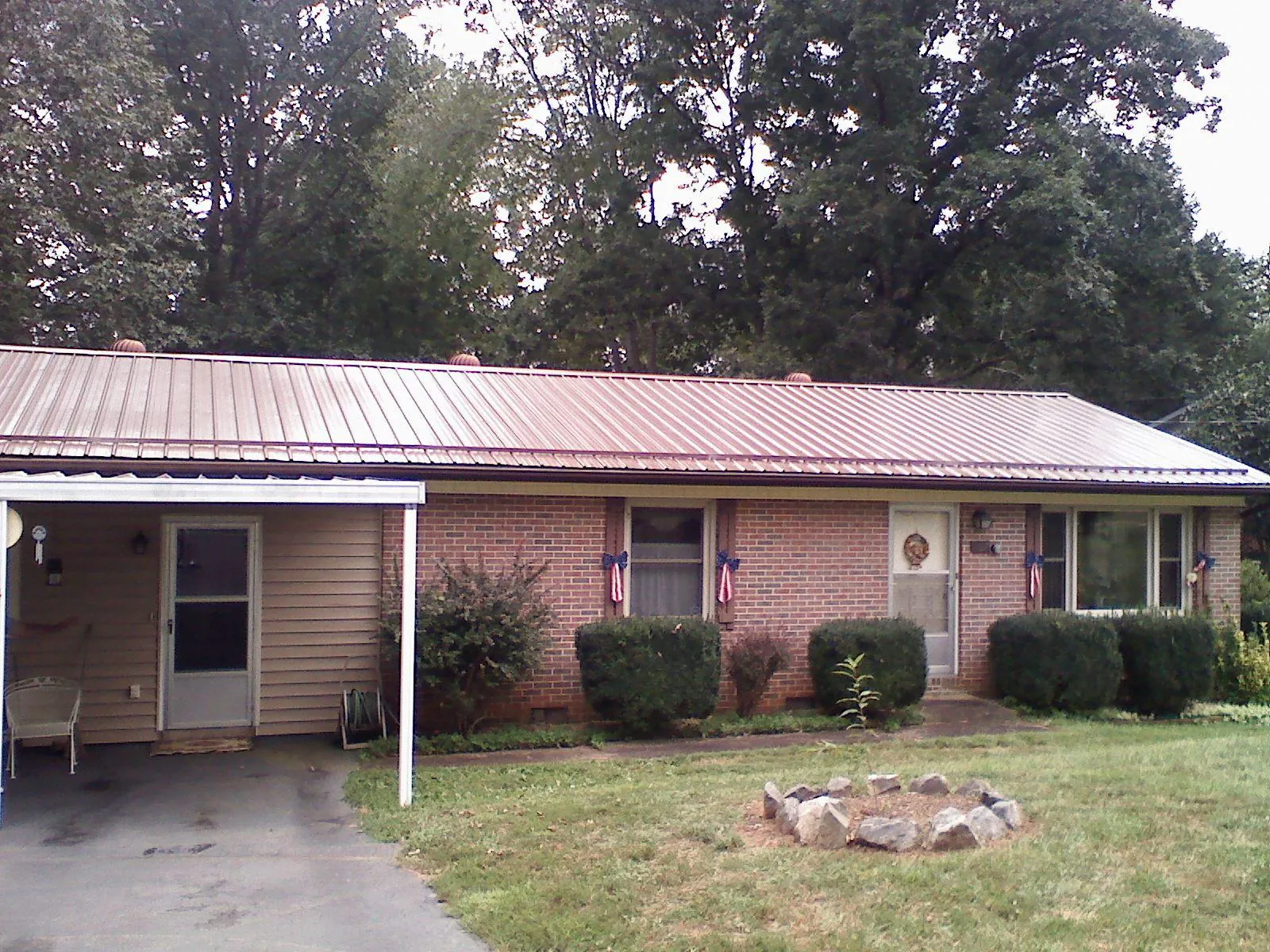 Bronze metal roof and carport on a brick ranch home — Roof Repair work by our crew in Mansfield
